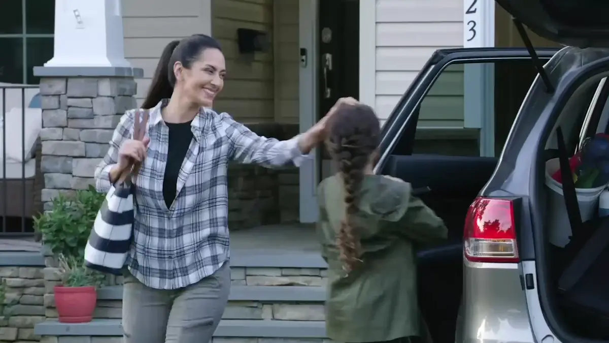 Mother and daughter arriving home with the car in the driveway